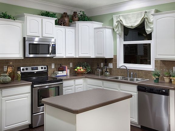 Tiered cabinetry and crown moulding highlight this open kitchen. An optional kitchen island offers a
