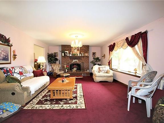 LARGE 23x15 Living Room boasting a Beautiful Log Burning Brick Fireplace w/ Heatilators, Gorgeous Candle-like Chandelier & Aweso