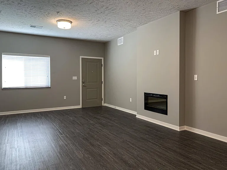 Relax in your living room featuring a cozy fireplace and plenty of natural light.