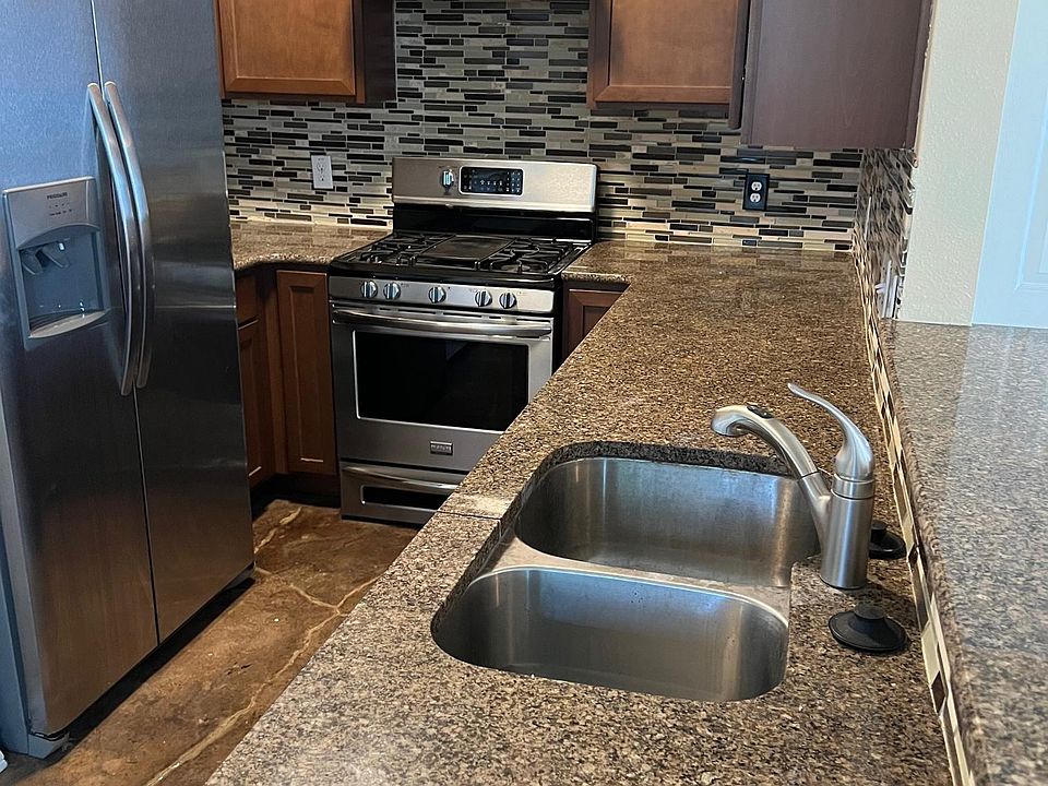 Kitchen with stainless steel appliances, granite counter tops with direct view of first floor living area.