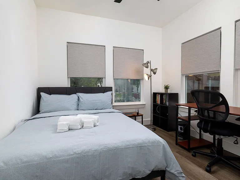 Third bedroom featuring queen bed and designated workplace.