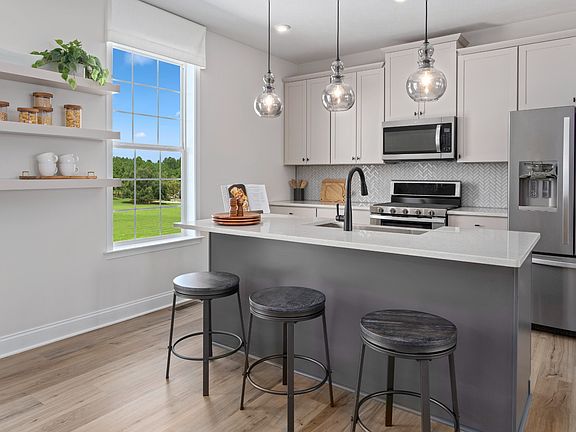 Island kitchen with large window in a DRB Homes Whitaker II model at the Rolling Hills community.