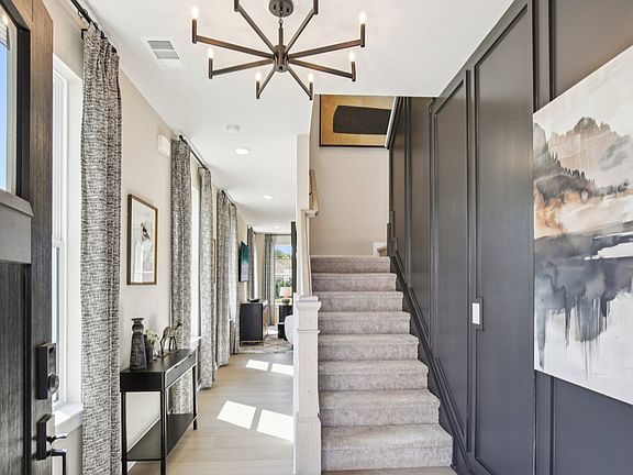 Entry with accent wall, hallway to living room, and staircase