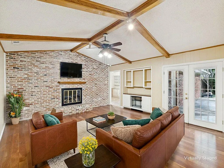 The family room is the center of the home. Warm wood flooring, the original floor to ceiling gas fireplace and vaulted ceiling with lighted fan make it the perfect space for cozy nights.