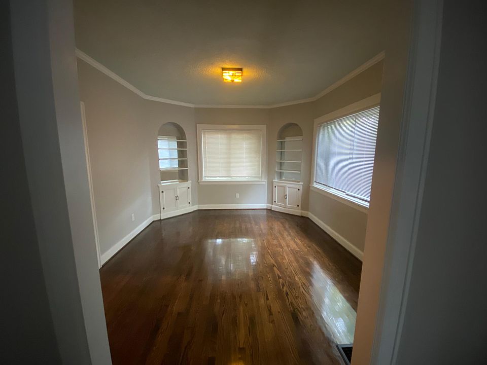 Large sunny dining room with vintage built-in storage and spectacular hardwood floors