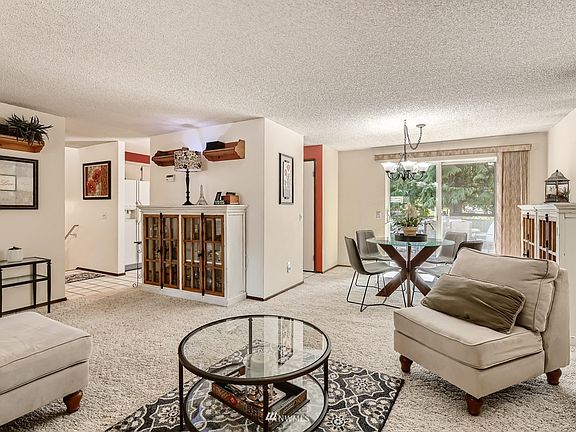 Standing near the fireplace you can see the stairs, the kitchen, the dining room and out onto the deck.