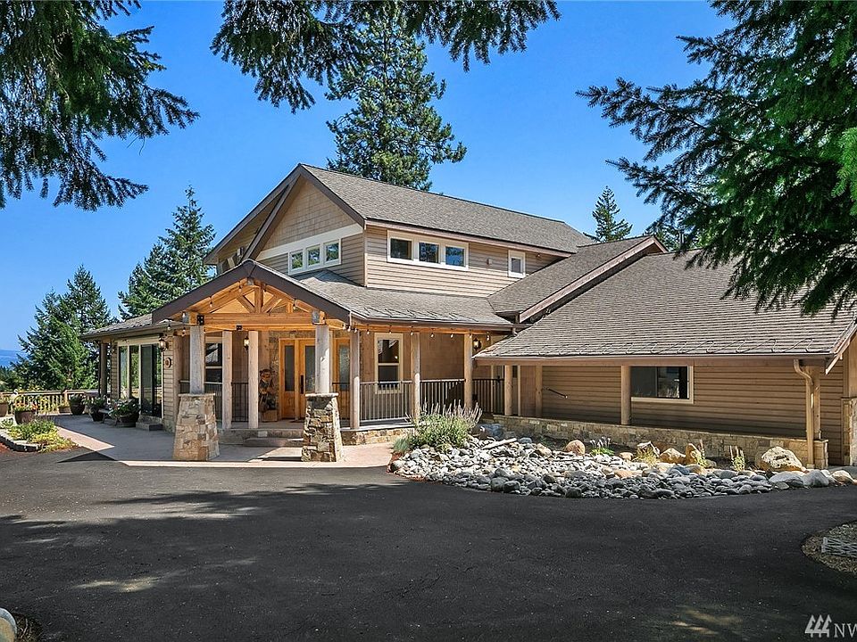 Impressive exposed beams on the covered entryway with log & stone pillars at this fully renovated Craftsman style home with easy year round access.