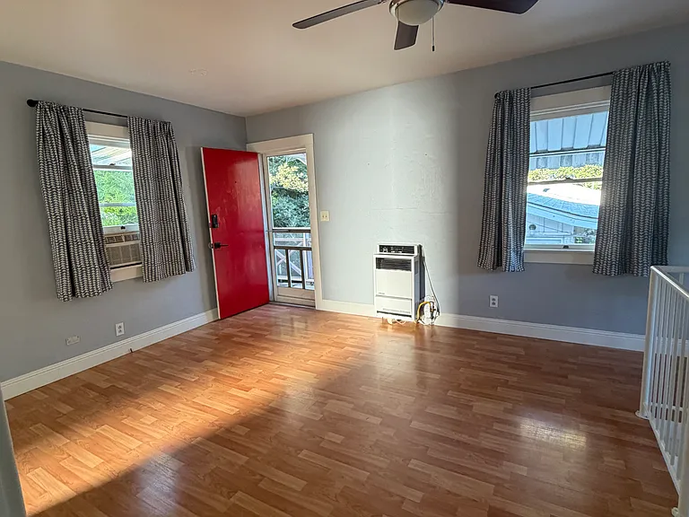 Welcome in! The charming two story home can be entered by the red front door, the downstairs bedroom door, or the upstairs bedroom door. The front door leads directly to the living/dining area.