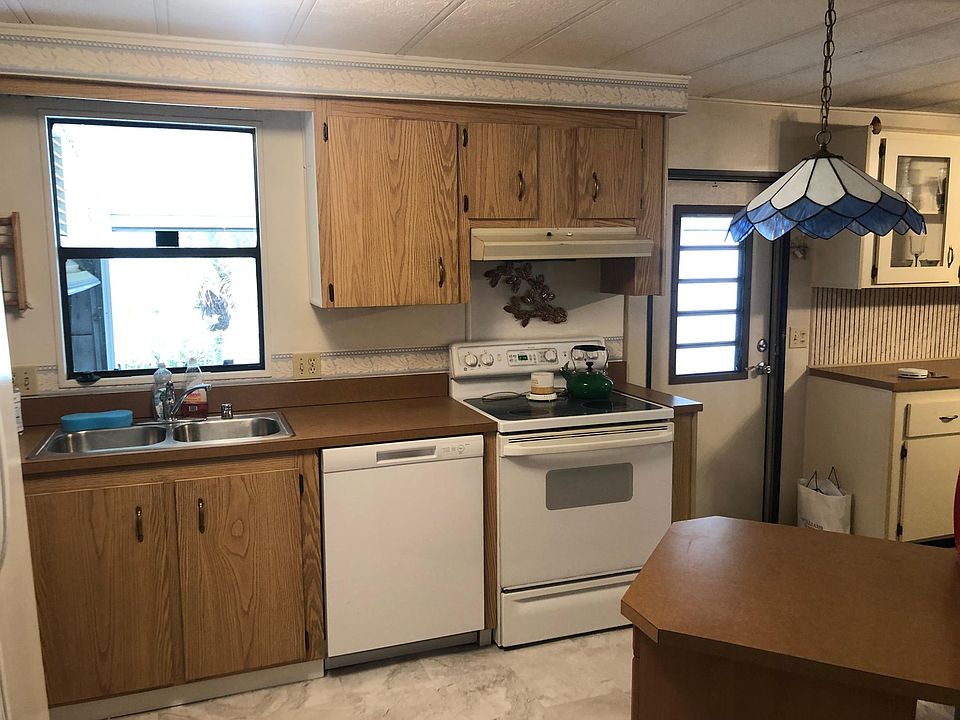 Kitchen with nice window over sink, disposal, new dishwasher and fridge. Lots of new cabinets, counters, pantry and utility closets. New floor! Fully stocked with kitchen appliances, dishes, pots/pans, right down to silverware.
