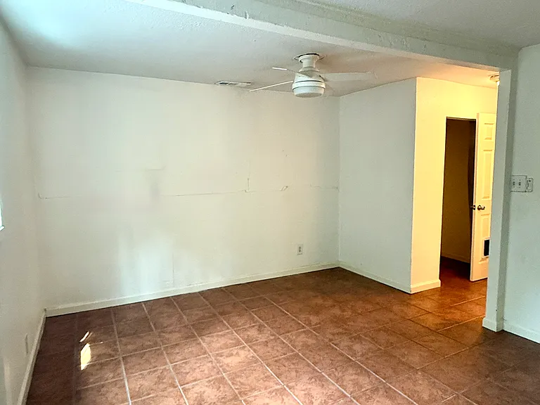 View of 3rd BR standing at rear entrance looking back into room; closet opening visible at start of small hallway leading to the bedroom suite's door.