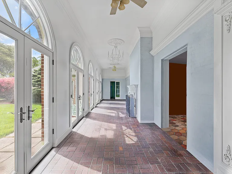 Sunroom with fans and glorious light, French doors open to courtyard.