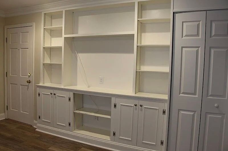 Living Area: Unit entrance door (on the left), built-in shelves, and kitchen pantry.