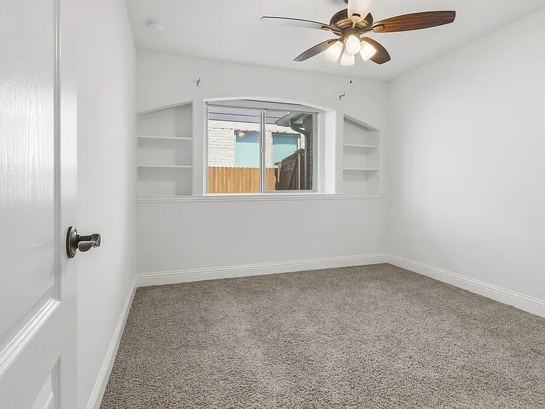 Carpeted 2nd Bedroom featuring a ceiling fan with integrated lighting, a window with a wood fence visible outside, and white baseboards