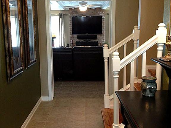 Spacious tiled foyer entry with charming wood staircase leading up to second floor.