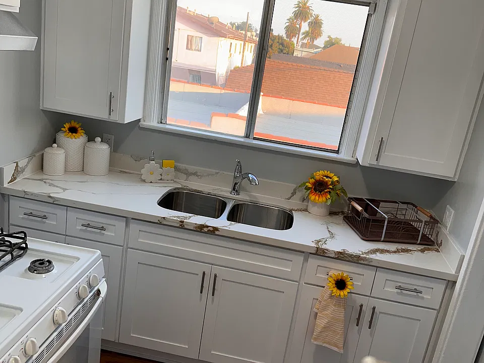 Kitchen with qaurz countertop and stainless steel double sink.