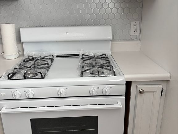 Gorgeous, clean backsplash and gas stove to cook your meals.