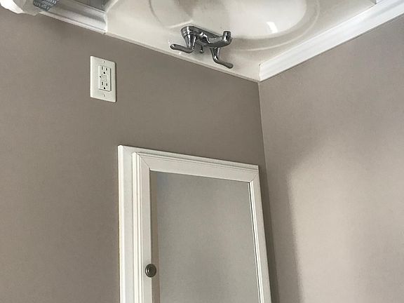 Bathroom includes updated bathroom sink, toilet. Tile floor. Small medicine cabinet