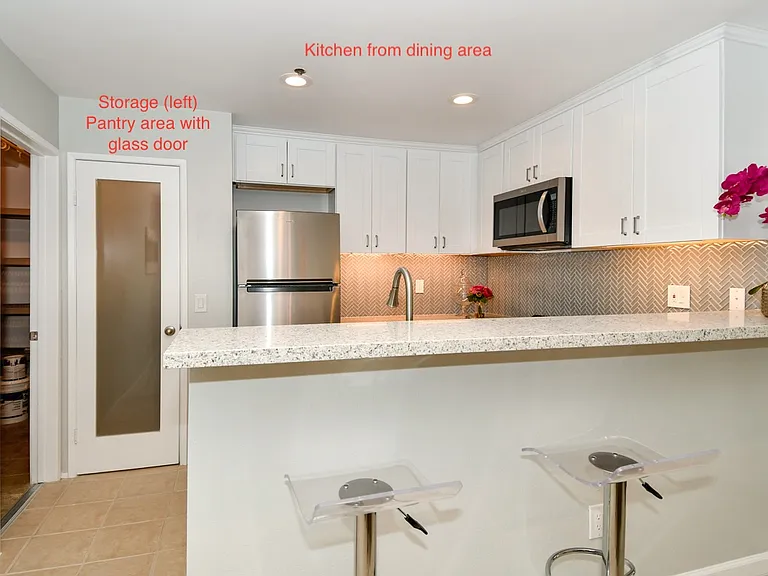 View of kitchen, pantry, and storage room from dining area
