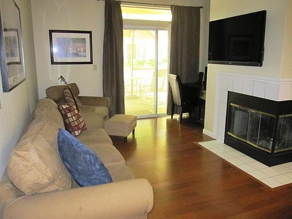 Living room with fireplace. Furniture shown as example.