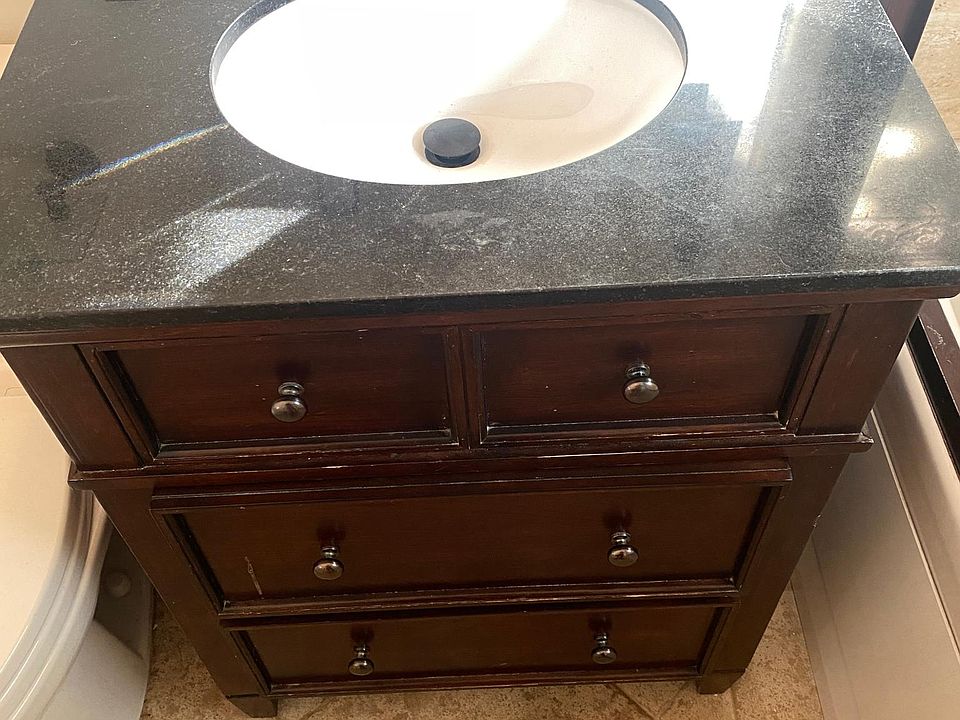 Granite top bathroom sink with two lower drawers.