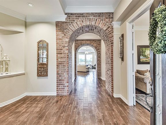 Gleaming wood-look tile greets you upon entry and continues throughout the home. The brick accented arches add an interesting architectural feature and draw the eye though to the pool views.