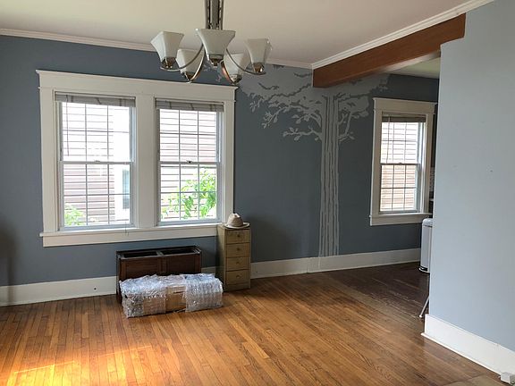 Dining room with a custom tree design on the wall.