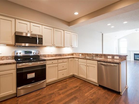 Kitchen makeover with beautiful new laminate flooring and stainless steel appliances.
