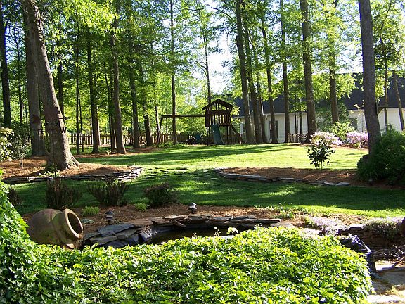 View from kitchen of backyard w/ pond, fountain and stone patio.