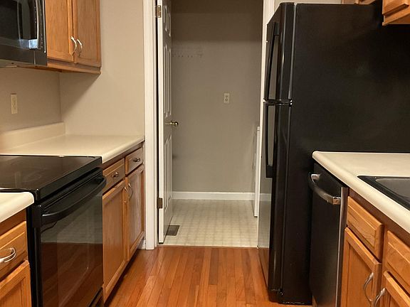 Kitchen with upgraded appliances, including ceramic top range, microwave, dishwasher and ice maker. Hardwood flooring.