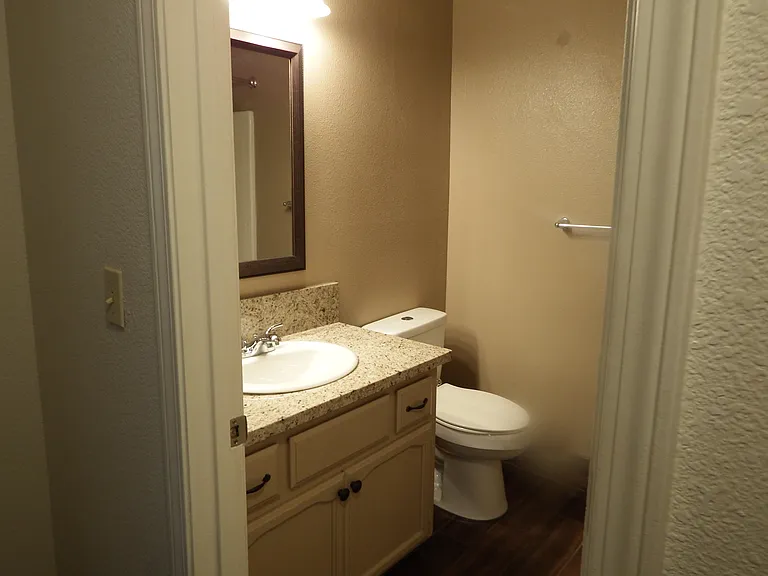 Hallway bath with granite counter top, modern vanity, framed mirror with updated lighting and chrome details.