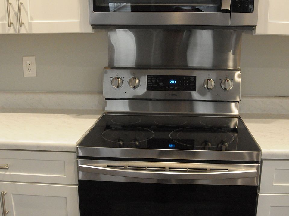 Kitchen showing microwave over ceramic electric stove.