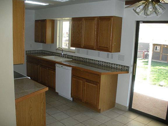 Kitchen with sliding glass door to large backyard with shed.