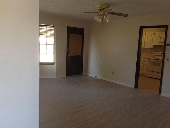 Living Room with back door to covered patio and fenced-in, very large back yard. Kitchen entryway is off to the right.