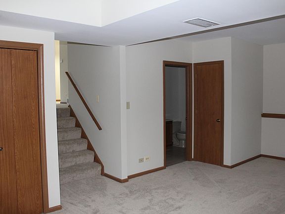 Downstairs 2nd living room. Door in front is a full bathroom with washer and dryer behind the door. Storage closet to right of bathroom door.