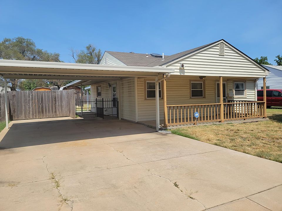Front of house with 2-car carport and covered patio. Lawn has irrigation system.