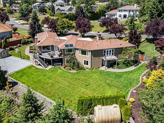 Backyard features mature fruit trees, raised garden beds, greenhouse, sport court and spa + outside access to main living area!
