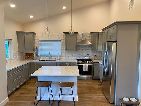 Open floor plan. Island, eat in kitchen. No touch faucet, gas stove, quartz countertops.