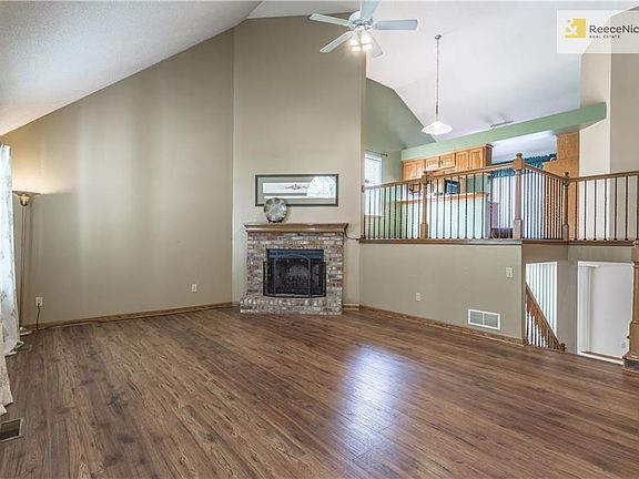 The front door opens into the Great Room with its soaring ceilings and brick, wood burning fireplace.