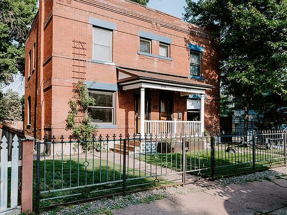 Original wrought-iron fence surrounds the front yard.