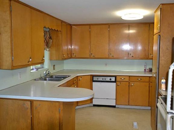 The kitchen has plenty of cabinets and lots of counter space.  The wood is in great condition. The entrance to the full basement is off of this area.