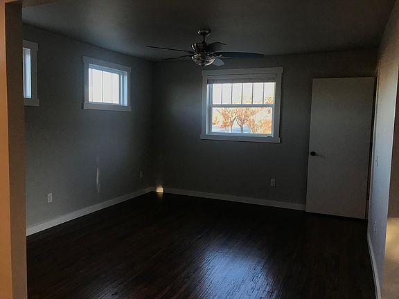 Living room with the front view of a giant sycamore and side windows letting in sunset views on the west. The open door on the r