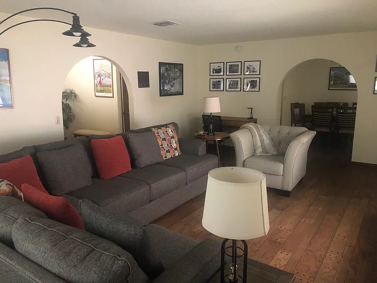Large living room with sectional sofa, extra chair, lots of plugins, and a desk and chair.