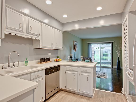 Light and bright kitchen with white cabinets, recessed lights, updated appliances and new floor.