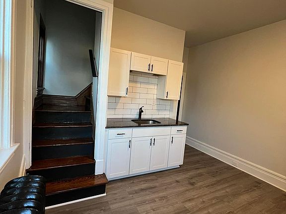 Kitchen looking from front entrance and stairs leading to upstairs bedroom and bathroom