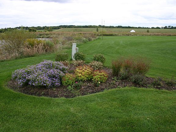 Rear yard has many perrenial beds, low maintenance & water!