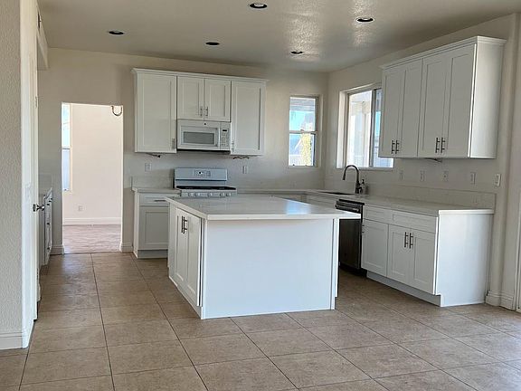 New appliances including range, microwave, sink, disposer, and faucet.