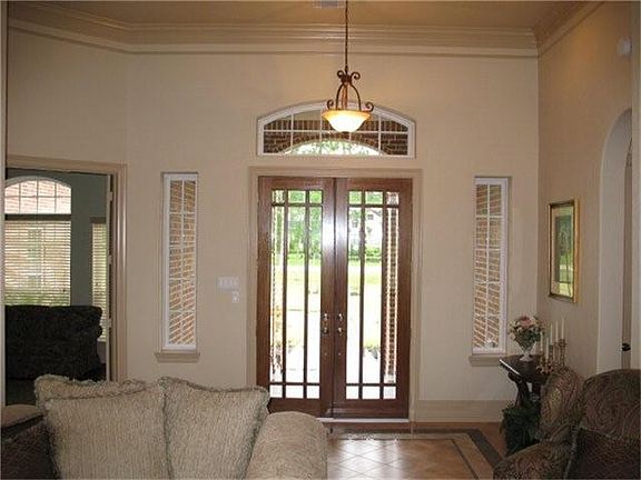  View of the Formal Living room looking at the glass double front doors, high ceiling and gorgeous designer flooring.