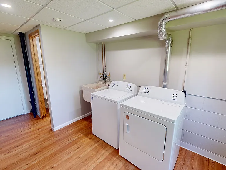 Basement view of laundry area and door to bathroom