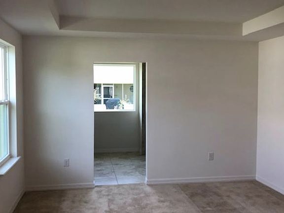 Oversized master bedroom with natural light and tray ceiling