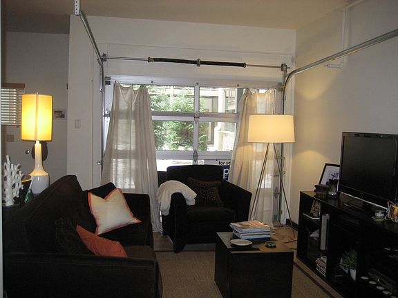Den with garage door that opens into the courtyard